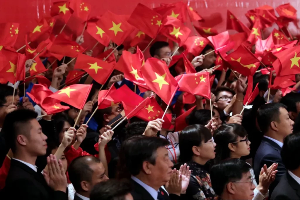 Giovani comunisti vietnamiti e cinesi sventolano bandiere per accogliere il presidente cinese Xi Jinping e il segretario generale del Partito comunista vietnamita Nguyen Phu Trong durante un incontro ad Hanoi il 6 novembre 2015. Foto: AFP / Na Son Nguyen